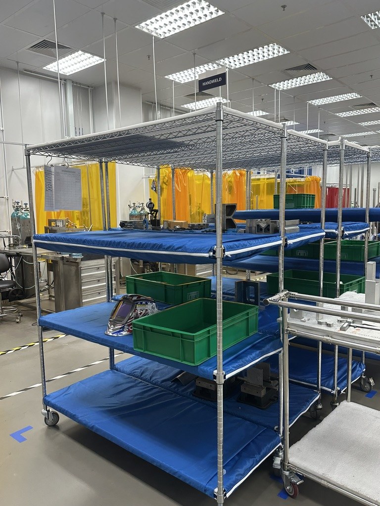 Blue ESD covers fitted to wire shelving in a hand-weld department